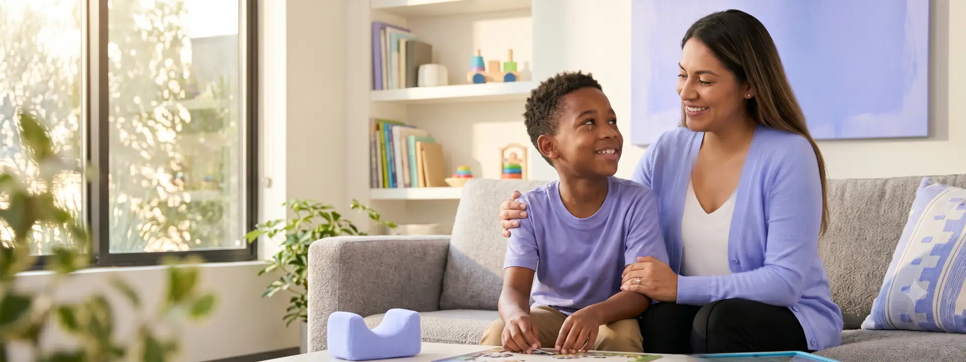 CCDB Applied Behavior Analysis (ABA) Therapy - mother smiling with her son on the couch